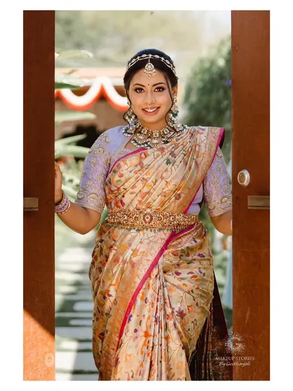 Nidhi making a grand entrance. Her makeup is bright and welcoming, with a beautiful smile that lights up the frame.