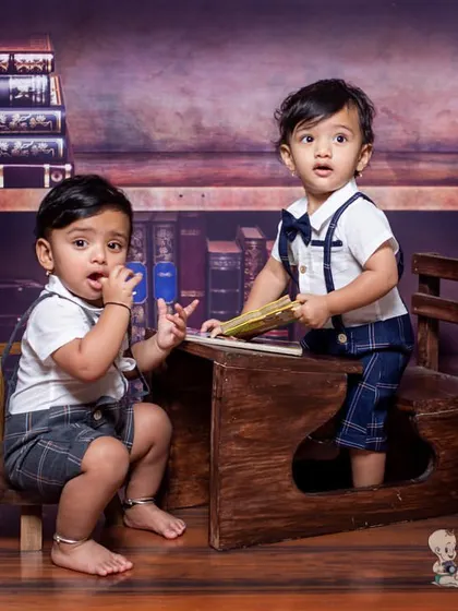 Two little scholars in our library-themed set. These twin boys in matching outfits look curious as they explore the desk and books, making for a very cute and clever photo.