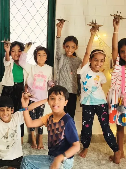 A group of happy campers proudly holding up the fighter jet models they assembled. This is a great project for developing fine motor skills and attention to detail.
