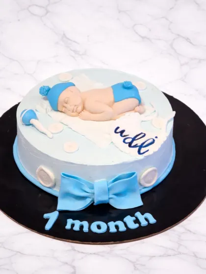 I love marking those precious baby milestones. This 7-month celebration cake features a hand-sculpted sleeping baby made from fondant, complete with a tiny rattle and a personalized name, all on a soft blue buttercream cake.