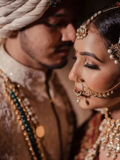 An intimate black and white close up of a bride and groom. This portrait focuses on the bride's serene expression and intricate nath (nose ring).
