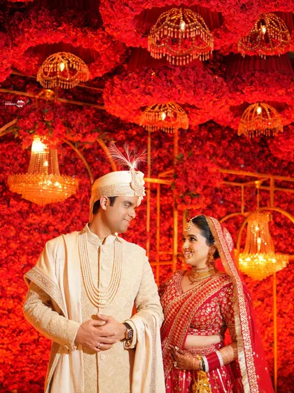 A lovely portrait of the couple against a stunning wall of red roses. Their matching smiles and the vibrant background create a picture of pure happiness.
