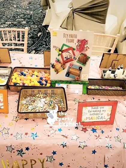 A DIY photo frame activity table. Guests could decorate their own frames with colorful pom-poms and gems as a magical keepsake from the party.