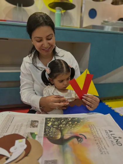 A mother and daughter create a volcano craft with the letter 'V'. Our themed crafts make learning letters and sounds more engaging and memorable.