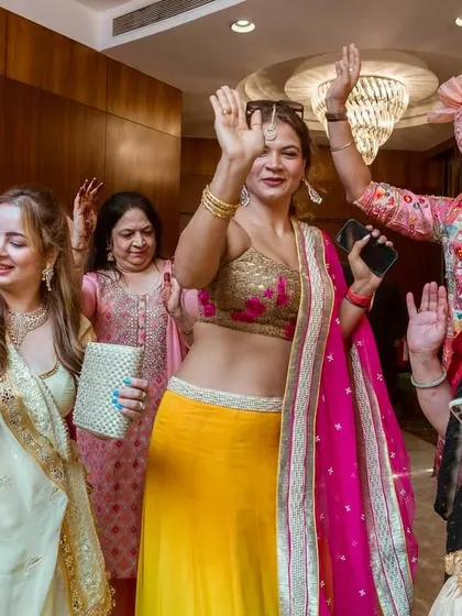 The ladies of the wedding show off their dance moves. The vibrant colors of their outfits and their happy expressions light up the room.