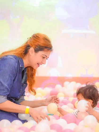 A candid moment between a mother and child, playing together in the ball pit.