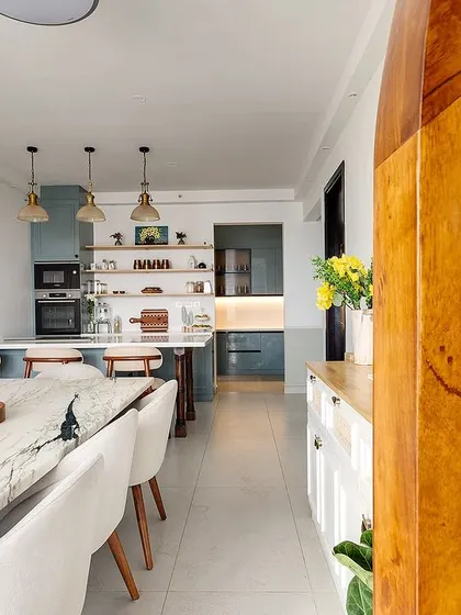 A peek into the open-plan kitchen and dining space, with a cane partition adding a touch of warmth and texture.