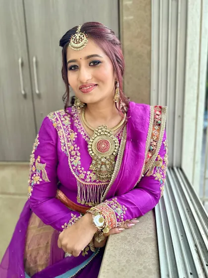 A close-up of this stunning purple look, showcasing the intricate jewelry and the flawless makeup.