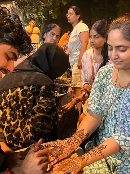 Applying mehandi for clients during the busy Karva Chauth festival.