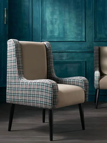 A wingback chair in the same plaid fabric, set against a moody, deep-teal wall. This demonstrates the versatility of the fabric, showing it can work in both light and dark interiors.