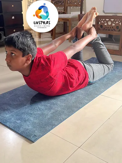 A young boy in Dhanurasana (Bow Pose), showing great flexibility and strength. Yoga helps children develop a positive relationship with their bodies.