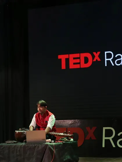 On the TEDx stage. The setup here included my sitar and a laptop, showing how I can integrate technology into my presentations.