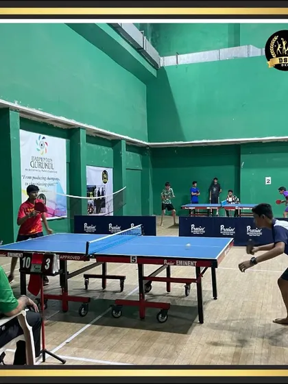An intense table tennis rally between two young players during a practice match. Our indoor hall provides ample space for competitive play and training.