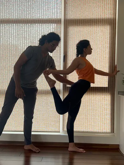 Working with a student on Natarajasana (Dancer's Pose) during a workshop. Expert guidance can help unlock challenging poses.