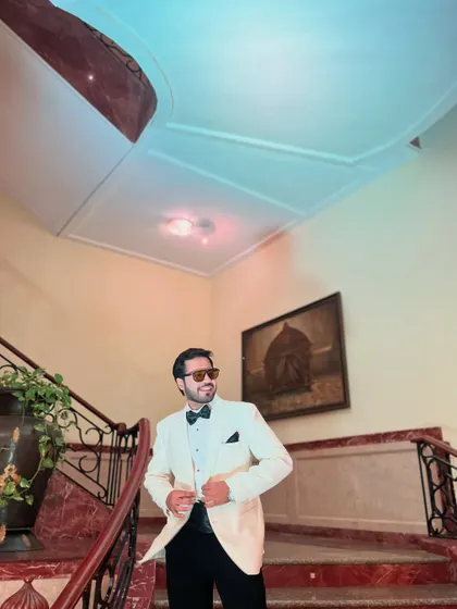 A confident and happy look in a white tuxedo, ready to host a memorable evening.