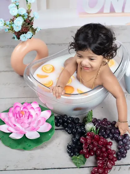 This little one is reaching for more grapes to add to her fruity bath.