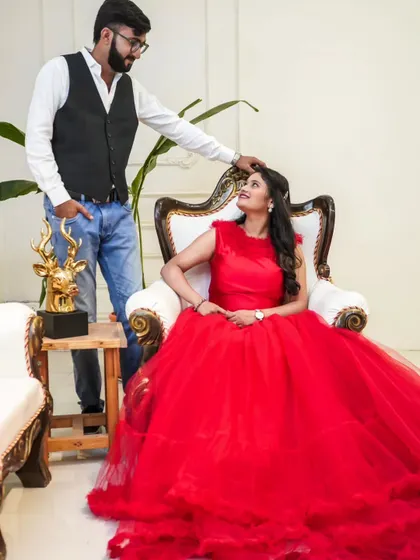 A regal portrait for a beautiful couple. The bride looks stunning seated in this ornate chair, her red ball gown spreading out around her.