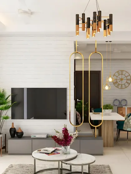 An open-plan living and dining area where the TV is mounted on a white brick accent wall. The simple grey console provides storage, while a decorative gold partition subtly separates the spaces.