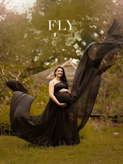 A dramatic shot with a flowing black gown. The makeup is elegant and understated, ensuring the focus remains on the beautiful mom-to-be.