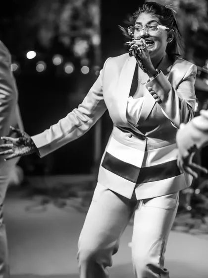 A candid black and white photo of our female vocalist dancing on stage. It's all about genuine fun and energy.