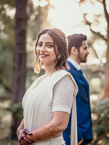 A beautiful, soft-focus shot of the bride smiling towards the camera while her partner stands behind her. It’s a moment of quiet confidence and happiness.