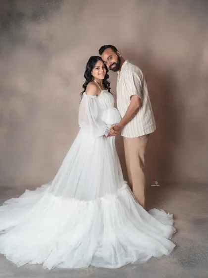 A beautiful, light-filled portrait of a couple ready to welcome their baby. The flowing white gown and their gentle hold create a feeling of pure love and serenity.