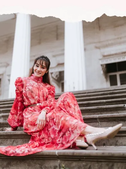 A lovely portrait on the steps of a colonial-era building. The setting and her elegant dress create a timeless, graceful look.