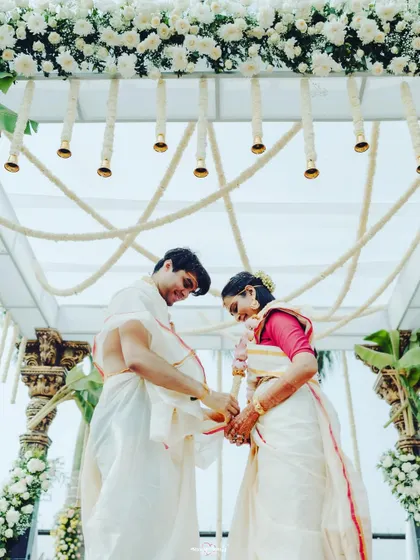The couple tying the sacred knot, a symbolic and emotional moment framed by the elegant white floral mandap.