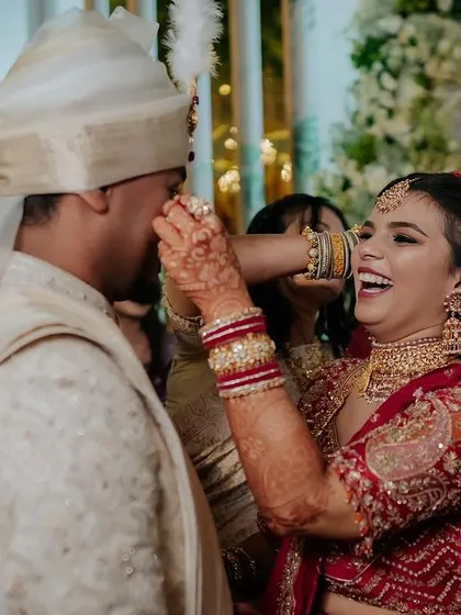 A regal bride in her magnificent red lehenga. We capture the grandeur of the bridal attire, creating portraits that are both powerful and elegant.