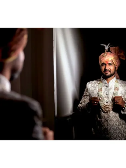 The groom getting ready, looking in the mirror, a classic and essential shot for the wedding album.