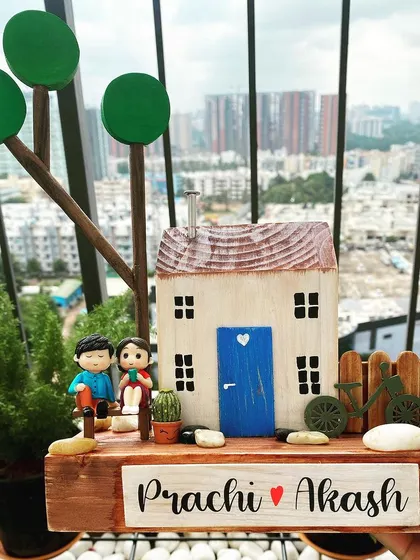 Set against a city skyline, this nameplate captures the feeling of finding your peaceful haven. The design features a couple on a bench, a tiny bicycle, and lush trees, all handcrafted from wood.