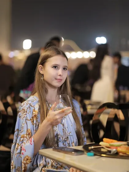 A young guest holds a glass, taking in the festive atmosphere of the event. We cater to guests of all ages, ensuring everyone has a wonderful time.