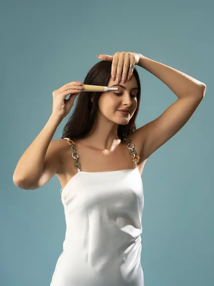 A demonstration of an eyebrow grooming tool. This close-up is perfect for showing the precision and function of the product.