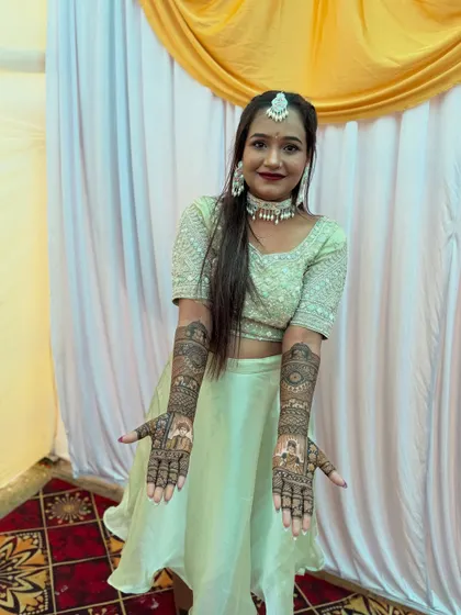 A full-length portrait of the bride, looking radiant. She is proudly displaying her bridal mehndi, which features custom portraits and intricate patterns, completing her stunning look.