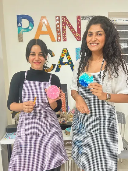 Two friends having fun painting coasters in our bright and airy studio.