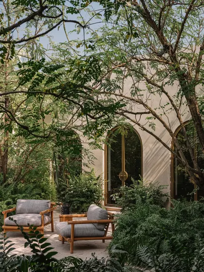 A quiet seating area at the Dua Villa, nestled within a lush garden. This space exemplifies our goal of blurring the lines between indoor and outdoor living, creating verdant sanctuaries for slow, contemplative moments.
