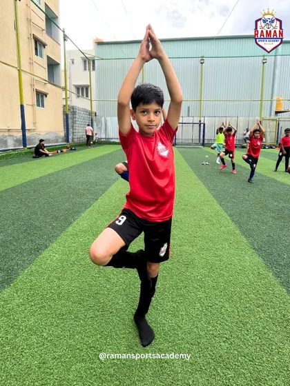 A young player holds a yoga pose with focus and determination, showcasing discipline beyond the football field.