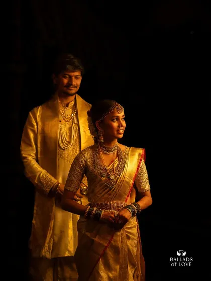 A classic portrait of a bride and groom. The bride's fully embroidered blouse shines against her traditional gold silk saree.