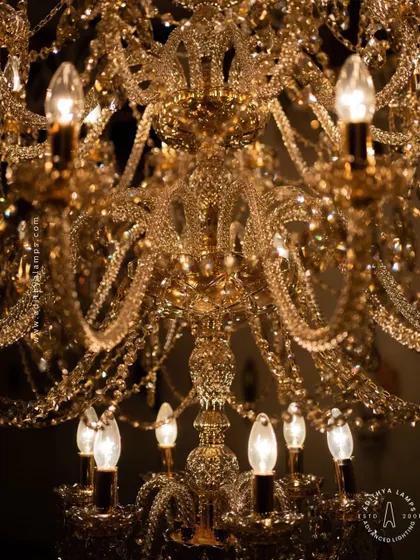 A detailed look at our magnificent multi-tiered crystal chandelier. Each arm is draped with shimmering crystal beads that reflect and refract light, creating an unparalleled sparkle. This fixture is a testament to classic European design and meticulous craftsmanship.