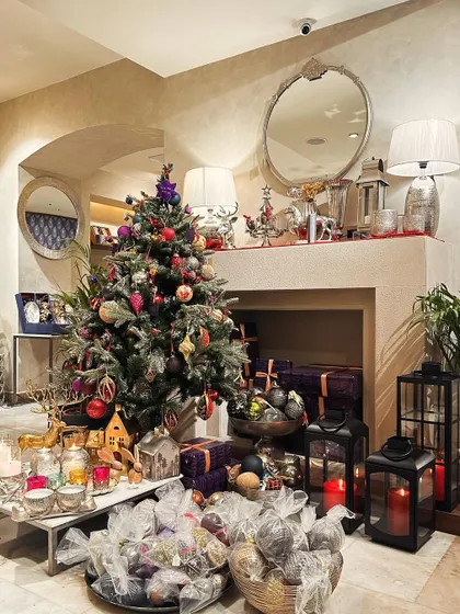A wide view of our in-store Christmas setup, complete with a decorated tree, a fireplace mantel styled with our decor, and lanterns of all sizes.