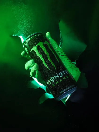 Another angle of the electrifying Monster energy drink shot. The added spray effect gives it a sense of power and explosive energy, perfect for the brand's image.