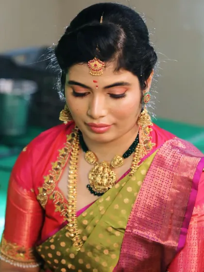 A simple and elegant makeover for a family function. This look features a soft pink eyeshadow and a matching lip, creating a fresh and youthful appearance that pairs well with her traditional attire.