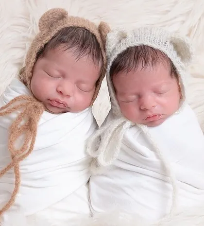 Double the cuteness with these twin baby bears. Swaddled in white and wearing adorable bear bonnets, they look so peaceful sleeping side by side.
