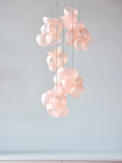 A vertical arrangement of pink Bocci 100 pendants, showcasing how they can be used to create a delicate, cascading light feature.