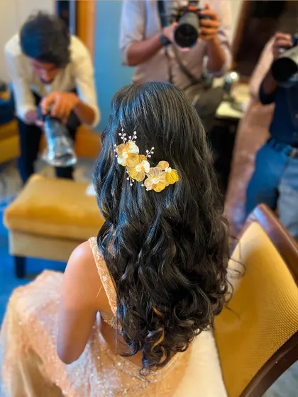 The final look of the golden floral half-updo, with photographers capturing its beauty. It's a glamorous and photo-ready style.
