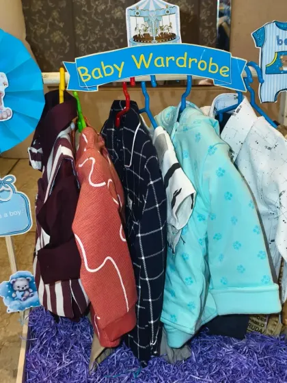 The 'Baby Wardrobe' for the twin baby boy, with a collection of smart and casual outfits arranged on a rack.