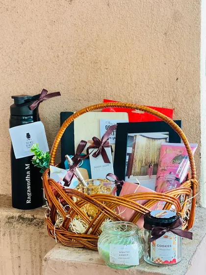 The farewell basket displayed outdoors, showing the personalized water bottle and other curated items like scented candles and cookies.