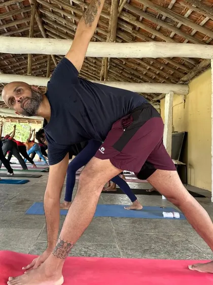 A student practices Trikonasana (Triangle Pose) at our Skandagiri retreat. The open space and fresh air enhance the feeling of expansion and grounding that this posture provides.