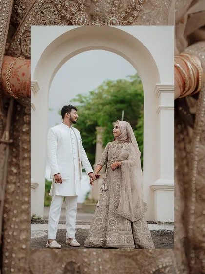 A beautifully framed portrait of a Muslim couple holding hands under an archway, creating a classic and romantic wedding photo.