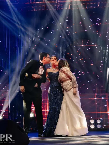 A precious moment where the parents kiss their daughter on stage after her performance.